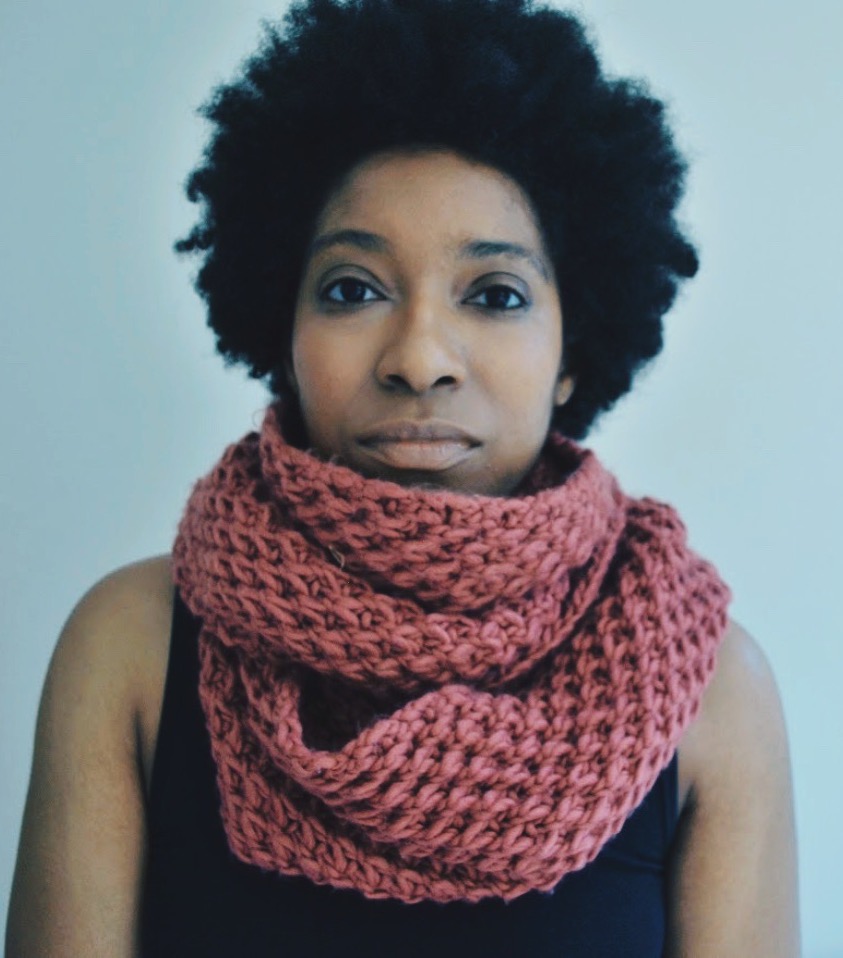 Image: black woman blue background pink scarf black top self portrait